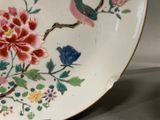 a plate with a bird and flowers painted on it