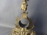 une horloge en or surmontée d'une statue