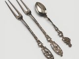 three spoons, a fork, and a spoon on a white surface