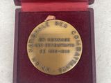 an image of a gold medal in a red box on a white surface