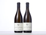 two bottles of white wine sitting on top of a table