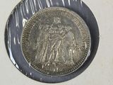 a silver coin with a picture of a woman and a man on it