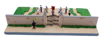 des figurines représentant des personnes debout devant un portail, disposées sur un gâteau