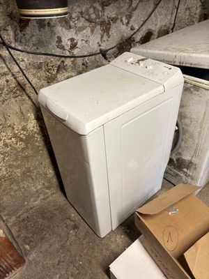 a white washing machine sitting next to a pile of boxes