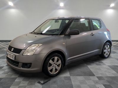 la petite voiture argentée est garée sur un carrelage à carreaux