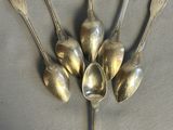 five spoons arranged in a circle on a table