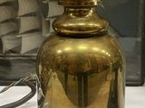 a gold lamp that is sitting on a white table