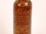 a brown vase that is sitting on a white surface