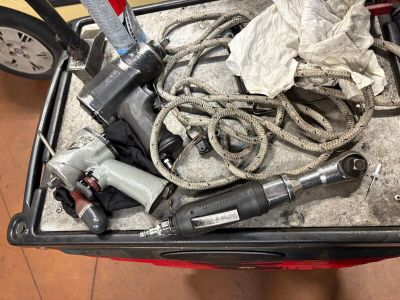 une boîte remplie d'outils posés sur le sol