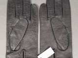 pair of black leather gloves with tags on them on a table