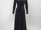 Le mannequin porte une robe noire et du rouge à lèvres rouge.
