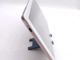 a tablet computer sitting on a stand on a white surface