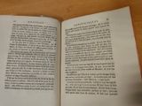 an open book on a wooden table with a mouse on it