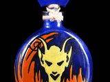 a small glass bottle with a picture of a devil on it