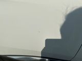 a shadow of a person on the side of a white car