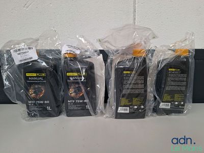 Quatre bouteilles d'huile moteur sont alignées sur une table