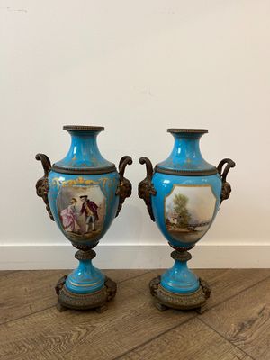 two blue vases sitting on top of a wooden floor next to each other