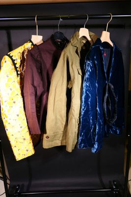 quatre vestes suspendues à un porte-manteau dans une pièce