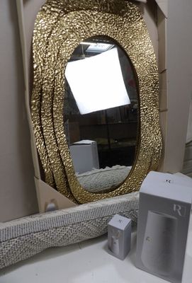 a bathroom sink with a gold mirror above it