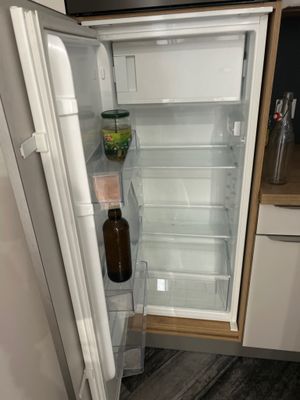 un réfrigérateur ouvert dans lequel se trouve une bouteille de bière