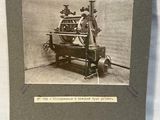 an old photo of a man standing next to a machine