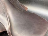 a close up of a brown leather shoe on a metal surface