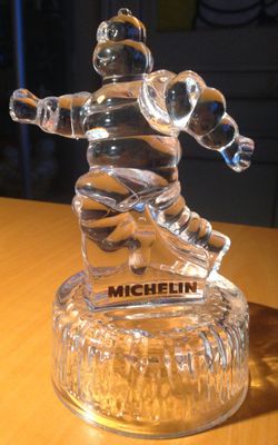 une figurine en verre représentant un homme, posée sur une table