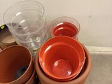 many pots and bowls sitting on a pallet next to a wall
