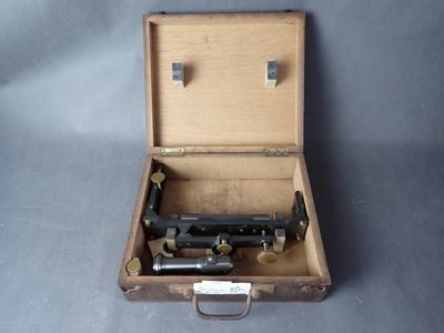 une valise posée sur une table, dans laquelle se trouve un pistolet