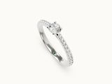 une bague sertie d'un diamant et d'une émeraude sur fond blanc