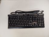 a black keyboard and a charger on a white table