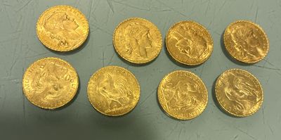 six gold sovereigns of various sizes and shapes on a table