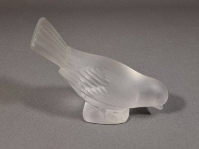 un petit oiseau en verre posé sur une table