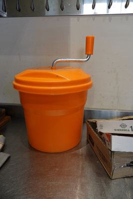 an orange bucket sitting on a counter next to a box of food