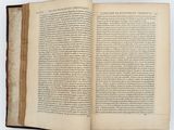 an open book on a white surface with a black border