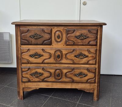 a wooden chest of drawers on a tiled floor