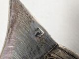 a close up of a silver object on a white surface
