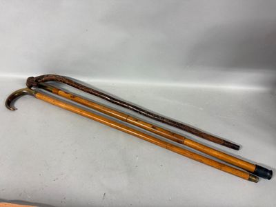 pair of old walking canes on a white surface with a wooden handle