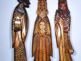 trois figurines en bois représentant trois hommes portant un chapeau et une barbe