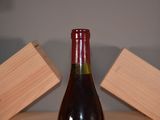 a bottle of wine sitting on a table next to a block of wood