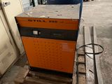 an orange and black machine sitting on top of a pallet in a warehouse