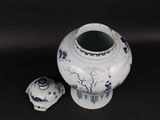 a blue and white vase with a lid sitting on a table
