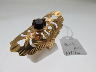une image représentant une bague en or sertie d'un grenat