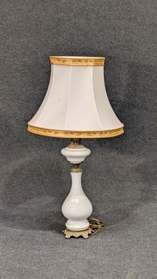 une image représentant une lampe blanche ornée d'une bordure dorée et d'un abat-jour blanc