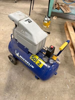 un petit compresseur d'air posé par terre dans le garage