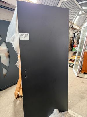 une porte noire au milieu d'une pièce