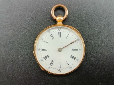 a gold pocket watch with roman numerals on the face
