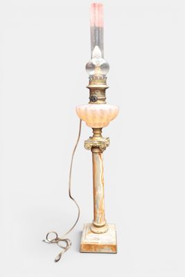 une lampe de table à l'ancienne, dotée d'un abat-jour en verre rose