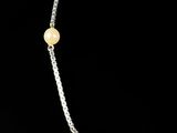 a close up of a necklace with pearls on a black background
