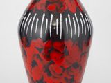 un vase rouge et noir orné de fleurs rouges